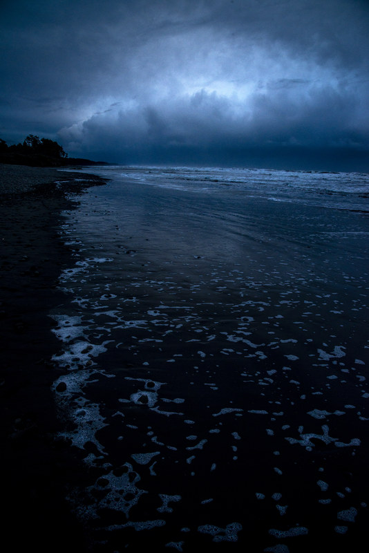 Dark storm cloud reflecting in the wet sand at Kalaloch Beach at night